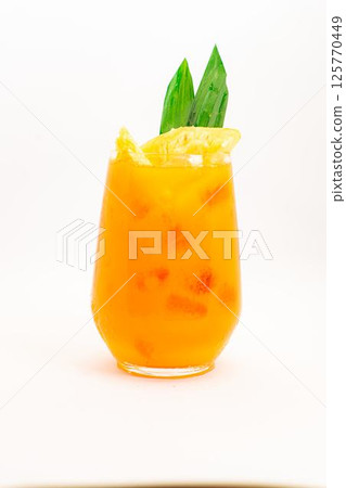 orange citrus cocktail with tropical leaf garnish served in transparent glass over ice on clean white background. High quality photo 125770449