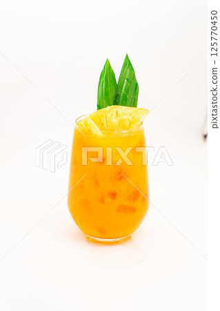 orange citrus cocktail with tropical leaf garnish served in transparent glass over ice on clean white background. High quality photo 125770450