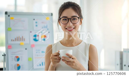 Smiling businesswoman holding coffee cup 125770606