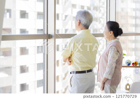 Seniors having a conversation by the window Seniors having a conversation by the window 125770729