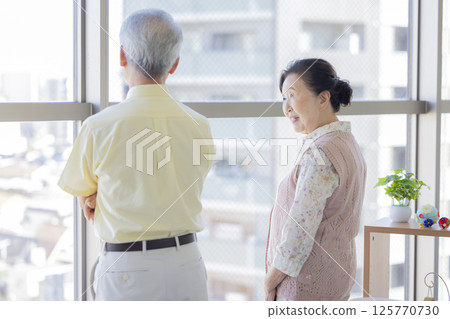 Seniors having a conversation by the window 125770730