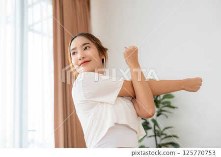 Young Asian beautiful woman doing stretch in the morning at home. Health care and body care concept 125770753