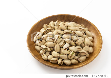 白色背景的木盤上的開心果 125770919