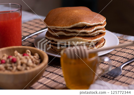 Pancake breakfast with honey and granola Pancake breakfast with honey and granola 125772344