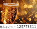 Champagne glasses and golden confetti flying, a glamorous moment for a party 125773311