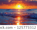 A spectacular view of the sunset over the ocean, flying birds, sparkling waves and a beautiful sunset 125773312