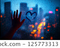 Heart and hand painted on a rainy window 125773313