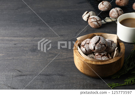 Delicious crinkle cookies in a plate, on a dark background. Delicious crinkle cookies in a plate, on a dark background. 125773597