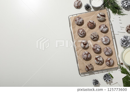 Appetizing crinkle cookies, on parchment, on a dark background. Appetizing crinkle cookies, on parchment, on a dark background. 125773600