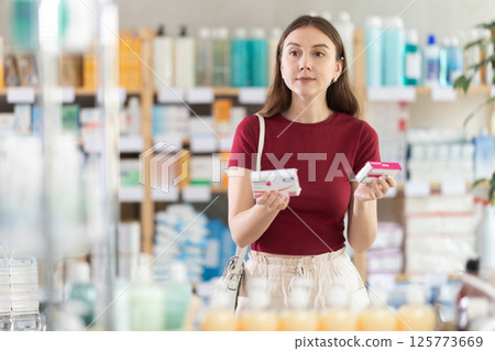 Woman buyer select paracetamol tablets in drug store Woman buyer select paracetamol tablets in drug store 125773669