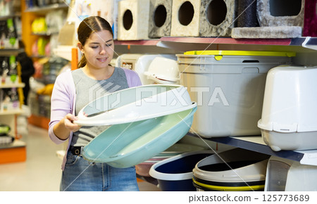 Female cat owner choosing plastic litter tray in pet shop Female cat owner choosing plastic litter tray in pet shop 125773689