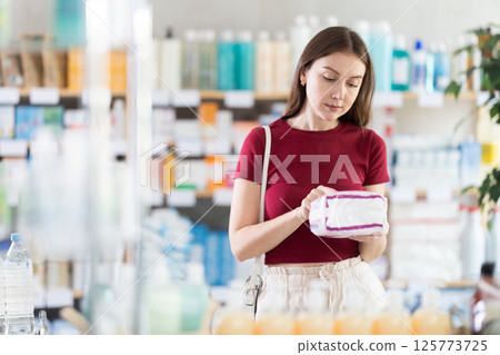 Woman choosing pads at the pharmacy Woman choosing pads at the pharmacy 125773725