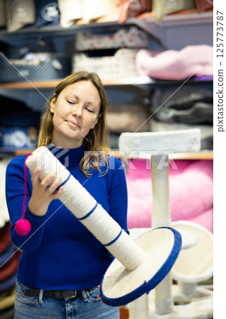 Woman choosing cat scratching post for cats in pet shop Woman choosing cat scratching post for cats in pet shop 125773787
