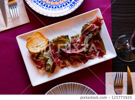 Sauteed artichoke hearts with slices of cured ham Sauteed artichoke hearts with slices of cured ham 125773920