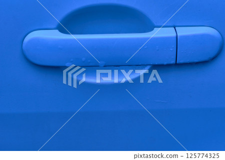 Evening blue car handle with lock, key hole after rain Evening blue car handle with lock, key hole after rain 125774325