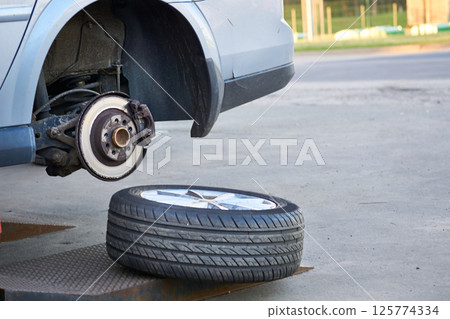 Service for the repair of a car wheels.Changing seasonal tires Service for the repair of a car wheels.Changing seasonal tires 125774334