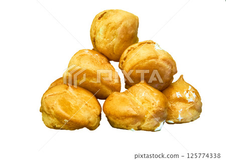 Delicious baked cakes profiteroles with cream on white Delicious baked cakes profiteroles with cream on white 125774338