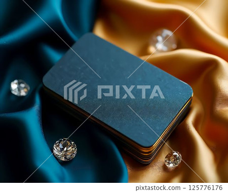 Elegant arrangement of blank business cards on luxurious fabric with decorative gems in the background 125776176