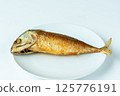 Fried short mackerel fish lies on white plate, showcasing its golden brown crispy texture 125776191