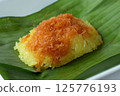Coconut flavored sticky rice with prawn topping sits on banana leaf 125776193