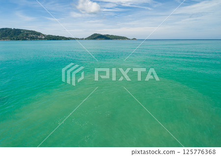 Aerial view of a blue sea surface water texture background and sun reflections Aerial flying drone view Waves water surface texture on sunny tropical ocean in Phuket island Thailand 125776368