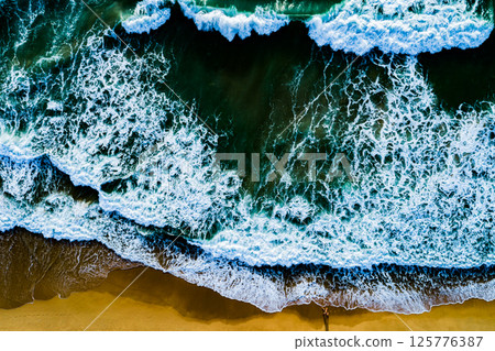 Top view Dark waves crashing on sandy shore beach background,Amazing waves sea nature background Top view Dark waves crashing on sandy shore beach background,Amazing waves sea nature background 125776387