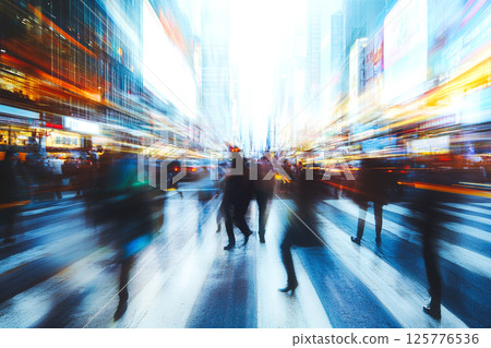 Abstract view of a busy urban crowd in motion, with a soft blur adding depth to the city street atmosphere. Blurry silhouettes of people walking in a busy city Abstract view of a busy urban crowd in motion, with a soft blur adding depth to the city street atmosphere. Blurry silhouettes of people walking in a busy city 125776536