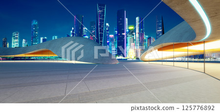 3d rendering Modern parking lot structure overlooking illuminated city skyline at night 125776892