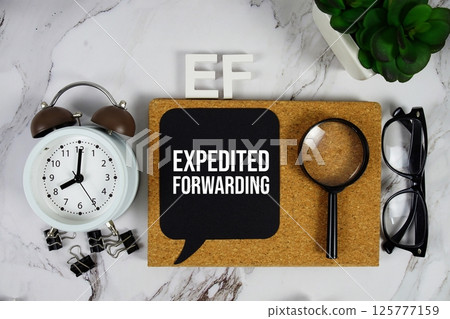EF - Expedited Forwarding acronym with alarm clock and magnifying glass, business concept background 125777159