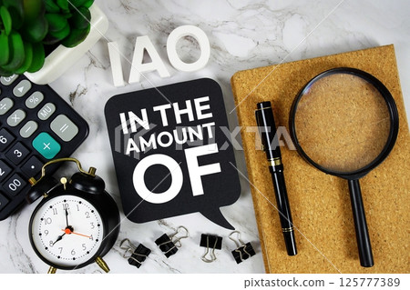 IAO - In the Amount Of acronym with calculator, alarm clock and magnifying glass, Business and Financial concept background 125777389