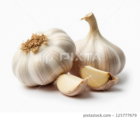 Fresh garlic cloves and bulbs arranged on a clean surface showcasing natural textures and colors in bright lighting 125777679