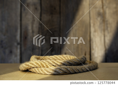 Natural Rope Pedestal on Rustic Wooden Background 125778044