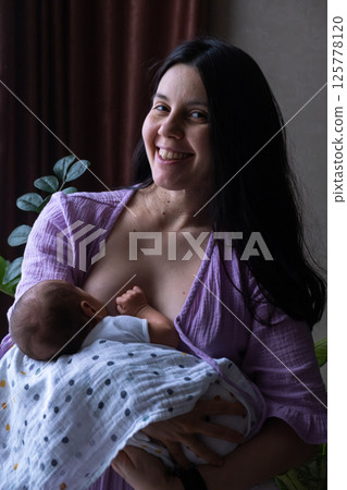 Mother Breastfeeding Baby by Window Mother Breastfeeding Baby by Window 125778120