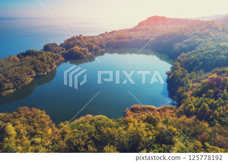 Picturesque mountain lake in autumn. Lake against the sea. Beautiful wilderness. Aerial view Picturesque mountain lake in autumn. Lake against the sea. Beautiful wilderness. Aerial view 125778192