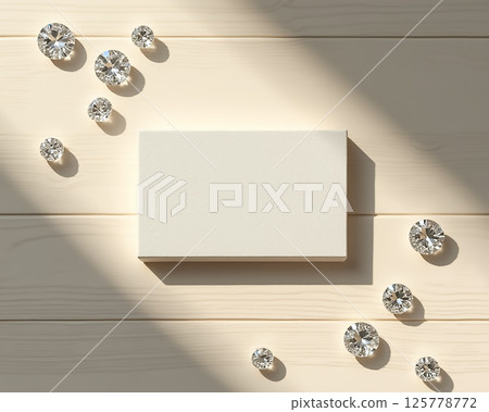 Elegant arrangement of sparkling gems around a blank card on a wooden surface illuminated by soft light Elegant arrangement of sparkling gems around a blank card on a wooden surface illuminated by soft light 125778772
