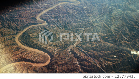 China. View From Airplane Window On Yongding River. Aerial View On Mountainous Terrain. Mountainous Landscape. Wuding River Or Unfixed River Because Its Flow Was Irregular. Porthole View China. View From Airplane Window On Yongding River. Aerial View On Mountainous Terrain. Mountainous Landscape. Wuding River Or Unfixed River Because Its Flow Was Irregular. Porthole View 125779433