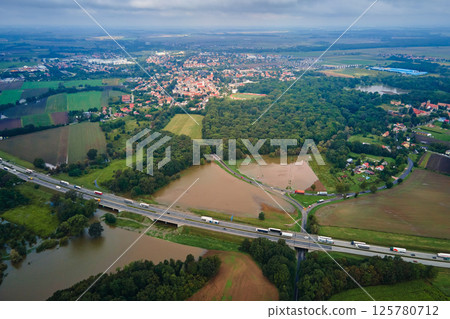 Flooded landscape with highway and rural town Flooded landscape with highway and rural town 125780712