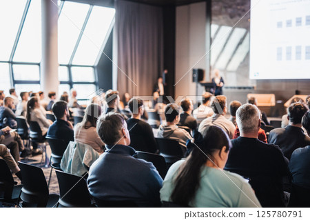 Female speaker giving a talk on corporate business conference. Unrecognizable people in audience at conference hall. Business and Entrepreneurship event Female speaker giving a talk on corporate business conference. Unrecognizable people in audience at conference hall. Business and Entrepreneurship event 125780791