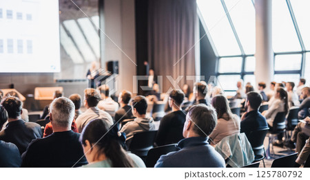 Female speaker giving a talk on corporate business conference. Unrecognizable people in audience at conference hall. Business and Entrepreneurship event Female speaker giving a talk on corporate business conference. Unrecognizable people in audience at conference hall. Business and Entrepreneurship event 125780792