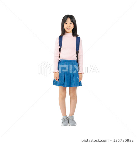 Smiling elementary school girl carrying a backpack. Full-body photo PNG with transparent background precisely cut out by hand. 125780982