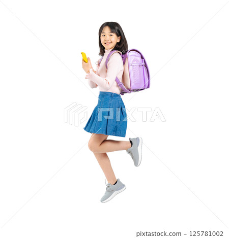 Elementary school girl jumping while using a smartphone. Full-body photo PNG with transparent background precisely cut out by hand. Elementary school girl jumping while using a smartphone. Full-body photo PNG with transparent background precisely cut out by hand. 125781002