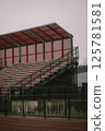A large stadium featuring bright red seats and a striking red roof 125781581