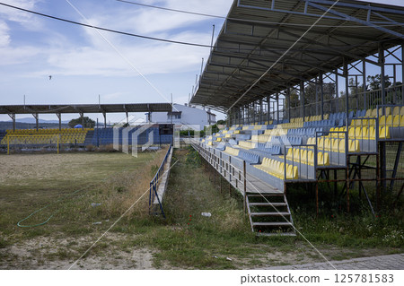 Abandoned stands of a football pitch on the beach 125781583