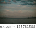 A bridge over water with a cloudy sky in the background 125781588