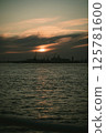 A sunset over water with a city in the background 125781600