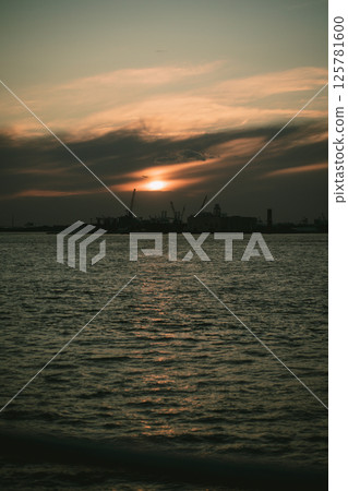 A sunset over water with a city in the background A sunset over water with a city in the background 125781600