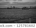 A black and white photo of a ferry with a city skyline 125781602