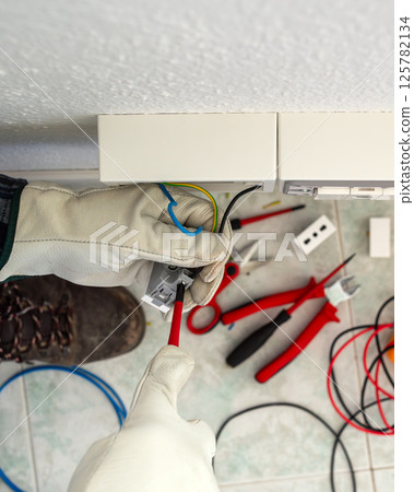 Electrician at work on a residential electrical system. Electricity. 125782134