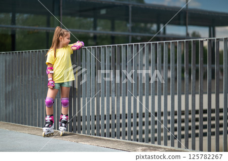 Little female skater practicing rollerblading skills for leisure Little female skater practicing rollerblading skills for leisure 125782267