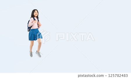 背著背包跳躍的小學生女孩全身照 背著背包跳躍的小學生女孩全身照 125782483